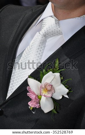presentable groom- white orchid boutonniere Royalty-Free Stock Photo #352528769