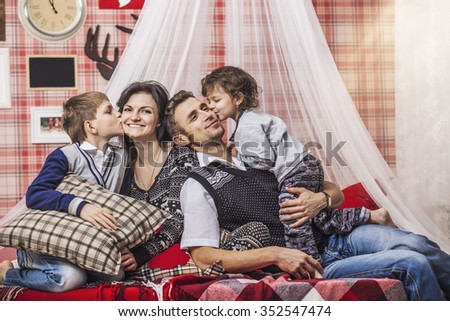 Family mum dad and kids together at home in the cosy atmosphere of the bedrooms in winter interior