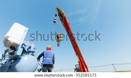 Industrial Crane operating lifting against sunlight and blue sky
