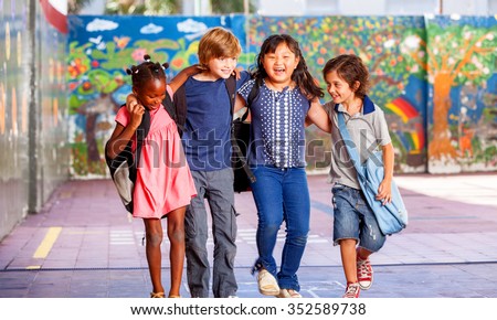 Schoolchildren embracing happy. Multi cultural racial classroom. Royalty-Free Stock Photo #352589738