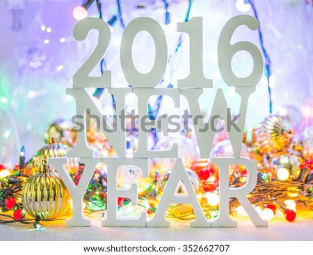 2016 New year white wood character over Defocused bokeh christmas light and christmas balls background