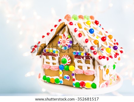Gingerbread house decorated with white royal icing and bright candies.