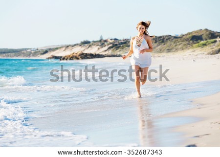 Portrait of young pretty woman walking along sandy beach
