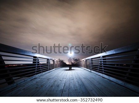 Shadowy Figure Holding Flashlight at Night - Light Concept Royalty-Free Stock Photo #352732490
