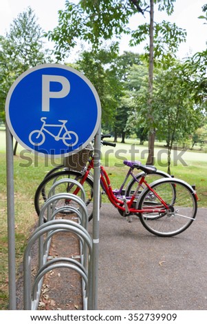 Bicycle parking sign with two bicycles in the parking lot.