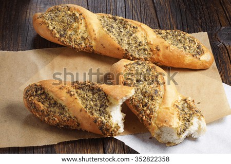 Small baguettes and two half filled with spice on old wooden table
