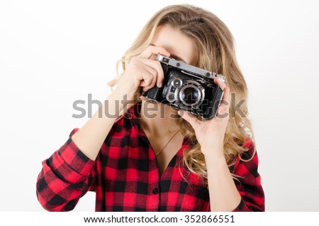 young woman holding old camera
