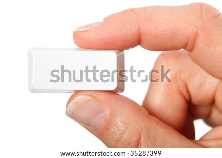 Just a small empty rectangular key from a computerkeyboard between fingers, white background