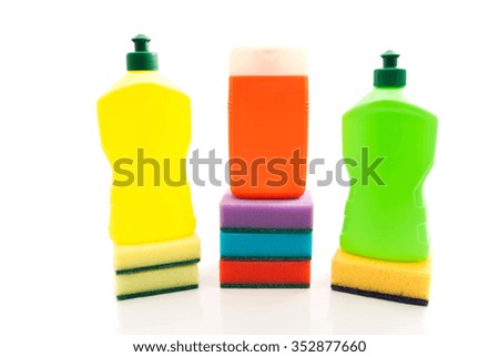 different bottles of detergent and sponges on white closeup