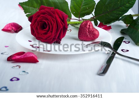 Romantic table setting with roses plates and cutlery