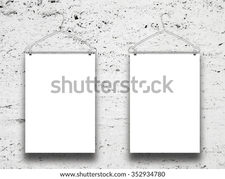 Close-up of white paper sheet frames with clothes-hanger on white marble wall background