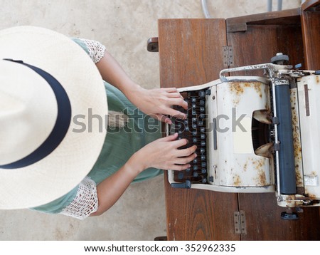 Unidentified woman's hand typing on retro typing machine  Royalty-Free Stock Photo #352962335