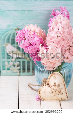  Postcard with fresh pink  hyacinths in vase and decorative heart  on white wooden planks. Selective focus. 

