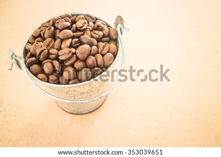 Coffee roasted bean in the bucket on wooden background, stock photo