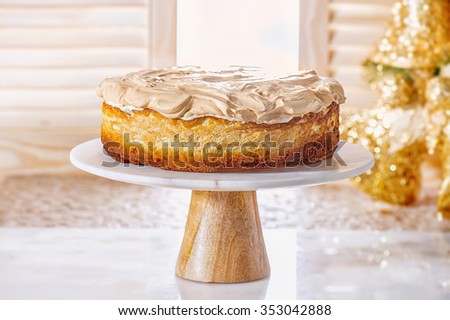 "Golden Rose" cheesecake with meringue (Polish cake). Whole new york style cheesecake on white plate