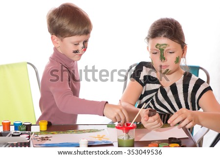 a boy and a girl having fun painting face painting