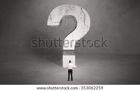 A small elegant business person in suit standing with his back in front of a huge question mark in open space concept