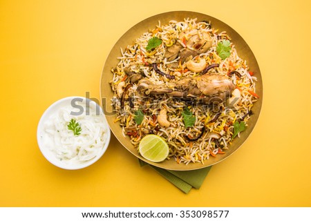 Chicken Biryani showing leg piece - It's a delicious recipe of Basmati rice mixed with with spicy marinated chicken in a bowl. Served with Salan or Raita. served in a bowl or plate. Selective focus Royalty-Free Stock Photo #353098577