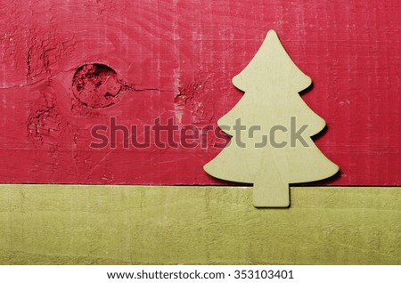 Simple green Christmas tree on a green and red wooden background.