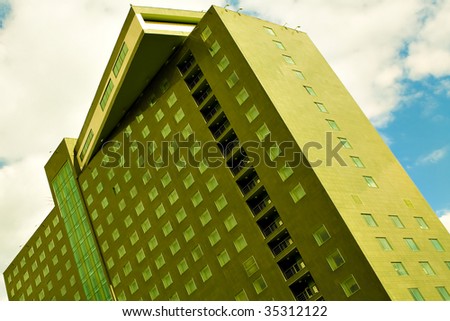 Green modern Hotel on blue sky with clouds