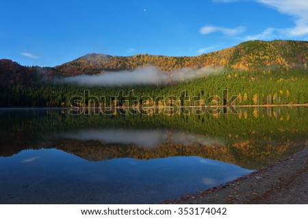 Autumn Landscape. Mountains in Autumn. The bright colors of autumn in the park by the lake.