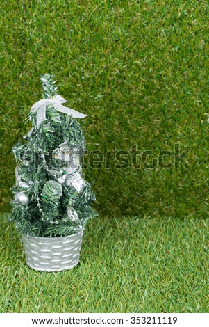 Silver Christmas tree on green grass background