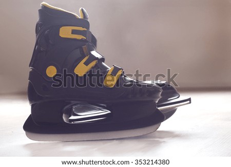 Close up of black plastic ice skates standing on ice rink