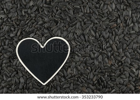 Heart pointer, the price tag lies on sunflower seeds,  with space for your text