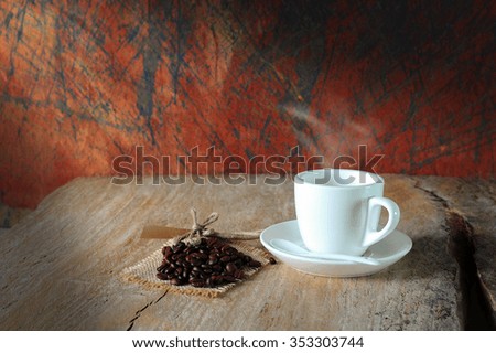warm cup of coffee and coffee beans on wooden background (Style Still Life)