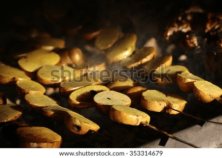 Photo closeup of delicious hot potatoes vegetables cooked on grill charbroiled barbecue on brazier on blurred smoky background, horizontal picture 