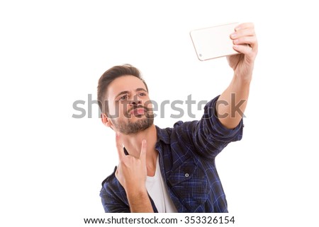 Happy young man taking self portrait photography through smart phone over white background.