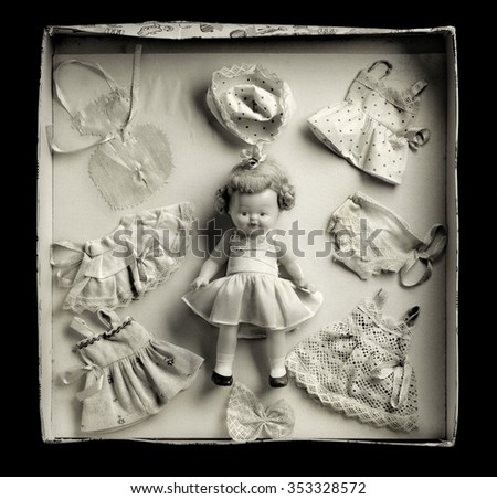 Medium format film photography shot with. Warm tone. Front view of vintage box doll game against black background.