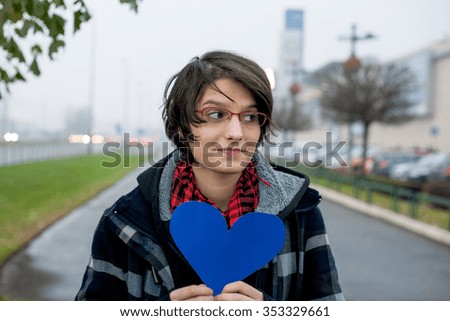 Young woman holding paper heart