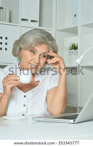 happy Elderly woman working on laptop in office