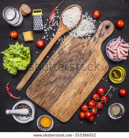 ingredients for risotto, rice, salt, pepper, tomatoes, ham, butter, cheese and grater on wooden rustic background top view close up
