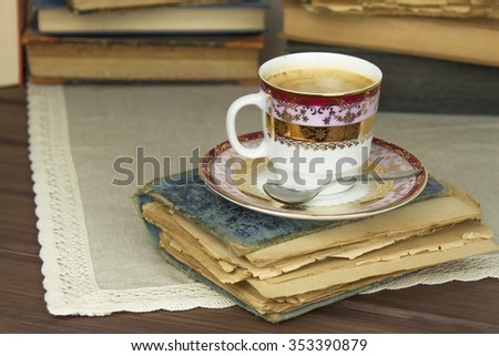 Porcelain cup of coffee and old books. Relax over coffee. Reading old books.