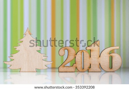 Wooden sign of 2016 year and Christmas tree on green striped background.