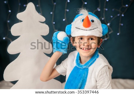 A boy in suit of snowman is throwing a snowball