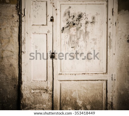 photo of old rusty door with a graffiti