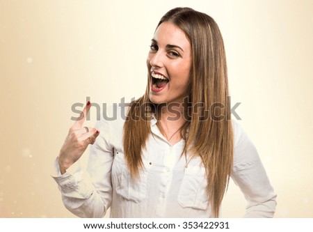 Blonde woman making horn gesture