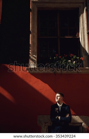 confident, cute groom in a stylish business suit, outdoors, summer