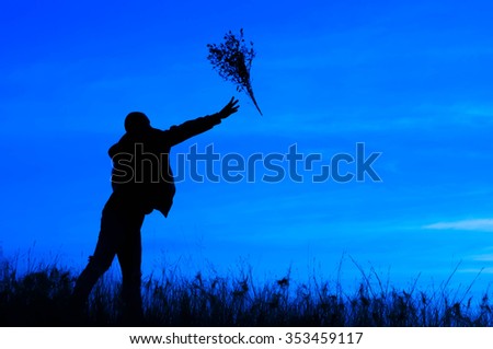 Silhouette of a man holding bunch of flowers. on bule background