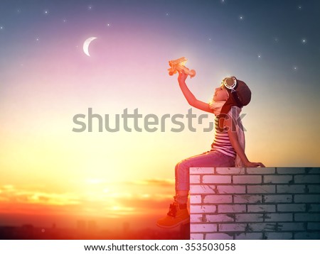 a child plays with a toy airplane in the sunset and dreams of becoming a pilot Royalty-Free Stock Photo #353503058