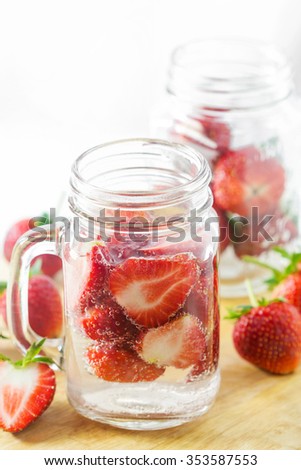Mug delicious refreshing drink of strawberry on wooden, infused water