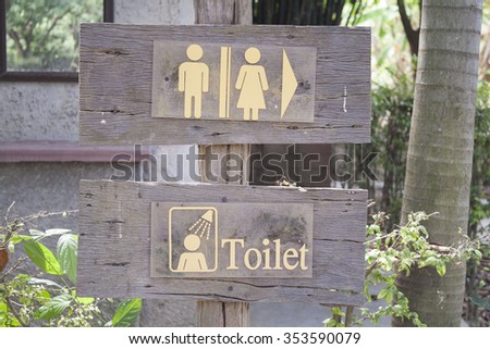 wood signs point to the bathroom