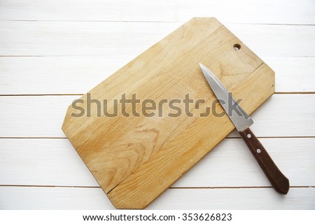 table with empty wooden cutting board and knife
