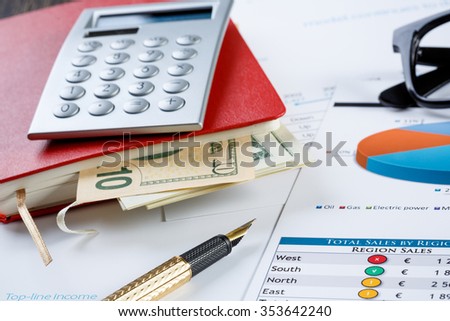 financial charts and graphs and a pen on the office table