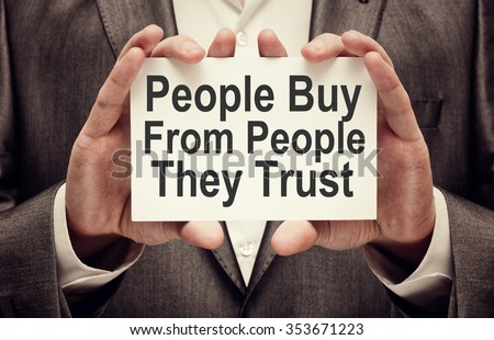 People Buy From People They Trust. Businessman holding a card with a message text written on it Royalty-Free Stock Photo #353671223