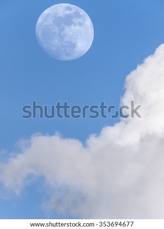 A waxing gibbous full moon against a blue sky and white clouds, Thailand