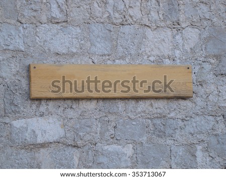 Wood sign hanging on a stone wall